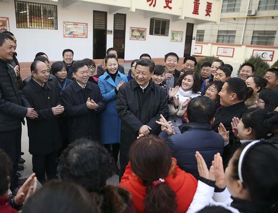 2015年2月14日上午，习近平在延安市杨家岭福州希望小学视察后，与闻讯赶来的附近群众亲切交流并向大家拜年。 新华社记者 兰红光 摄