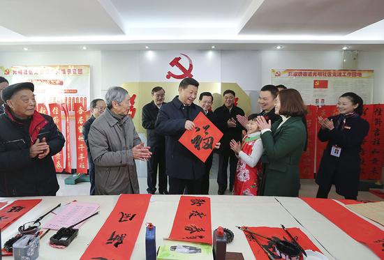 2016年2月3日，习近平在南昌市东湖区彭家桥街道光明社区书画室，接过一位小朋友现场书写的 “福”字，祝大家都幸福。新华社记者 兰红光 摄