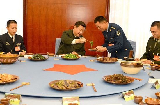 习近平与官兵吃“红军饭”，为官兵夹菜。据中国军网/军报记者